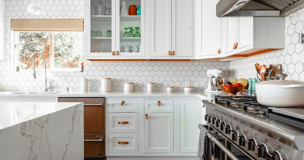 Bright kitchen with white cabinets, hexagon tile and a marble island