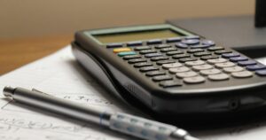 A calculator and a pen resting on a sheet of paper