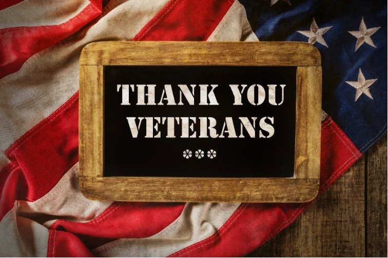 Thank You Veterans chalkboard sign resting on an American flag