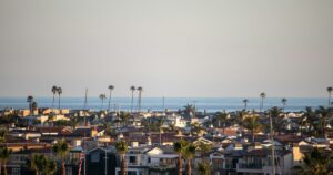 Homes with palm trees and the ocean in the distance