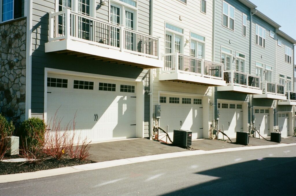 Row of townhomes with balconies and garages on a quiet street