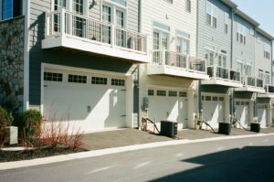 Row of townhomes with balconies and garages on a quiet street