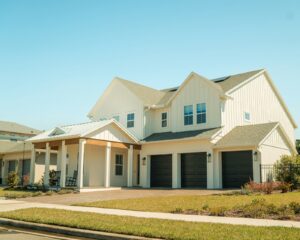 Two-story white suburban home with a three-car garage and green lawn