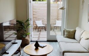 Bright living room with a sofa and French doors opening to a patio