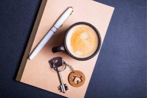 House keys, a coffee cup and a pen on a notepad