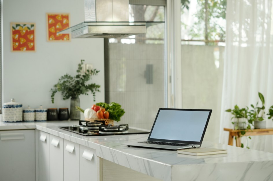 Laptop on a kitchen counter near a window
