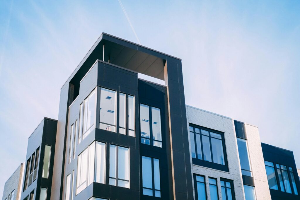 Modern condo building with large windows against a blue sky