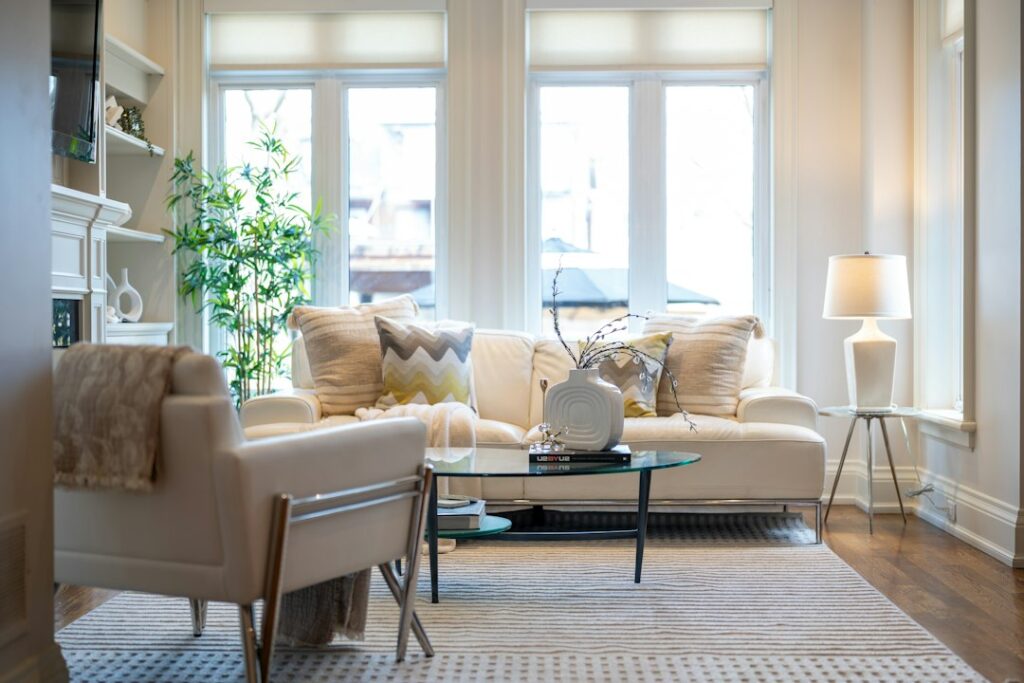 Bright living room with a cream sofa, armchair, and tall windows